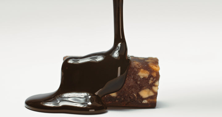 Simply chocolate date bar with chocolate syrup pouring over it