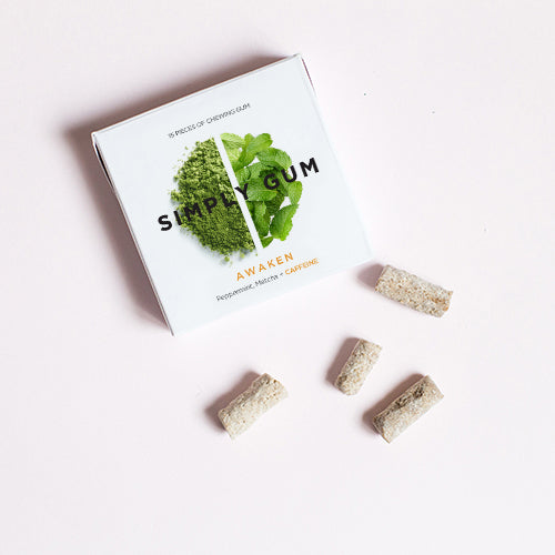 Pack of Awaken Gum on table with loose gum