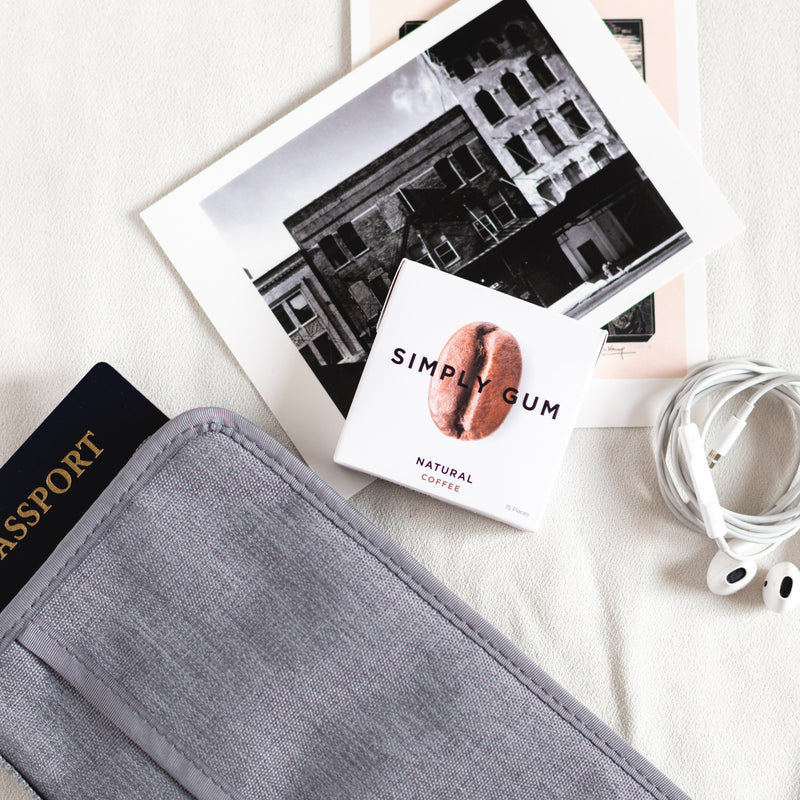 Pack of Coffee Gum on table with passport, postcard and headphones. 