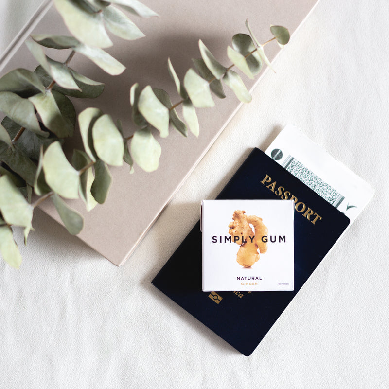 Pack of Ginger Gum on table with Passport and eucalyptus plant